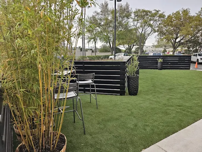 Close-up of bamboo planters and seating area on new commercial artificial turf