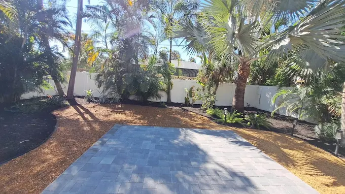 Low maintenance grey paver patio and golden sand in Winter Park backyard