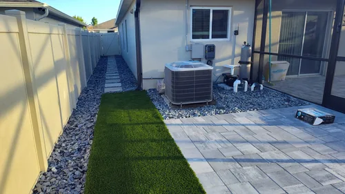 Paver walkway along the side of the house leading to the Winter Park backyard